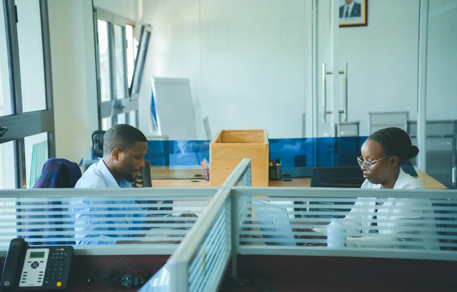 Colleagues working at separate desks in an office with glass partitions